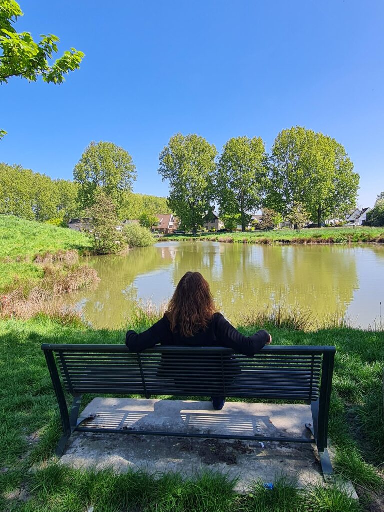 zittend op bankje bij water